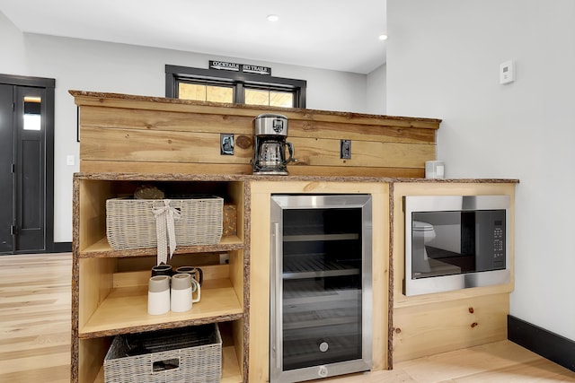 bar featuring wine cooler, light wood-style flooring, recessed lighting, baseboards, and stainless steel microwave