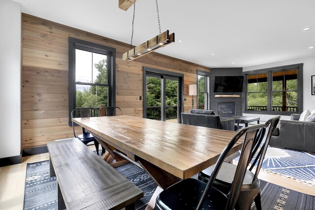 dining area with wood walls, a fireplace, wood finished floors, and recessed lighting