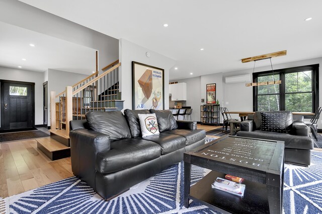 living area featuring stairway, wood finished floors, a wealth of natural light, and recessed lighting