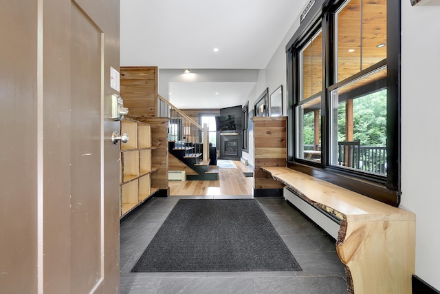 foyer entrance featuring plenty of natural light, stairway, baseboard heating, and recessed lighting