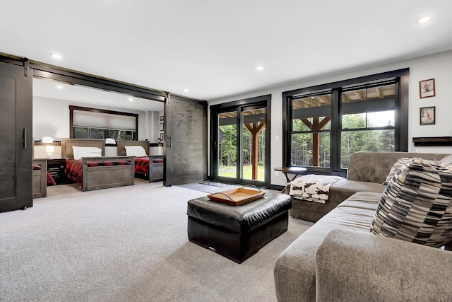 carpeted living room with a barn door and recessed lighting