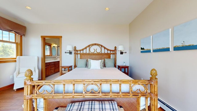 bedroom with hardwood / wood-style floors, ensuite bathroom, and a baseboard radiator