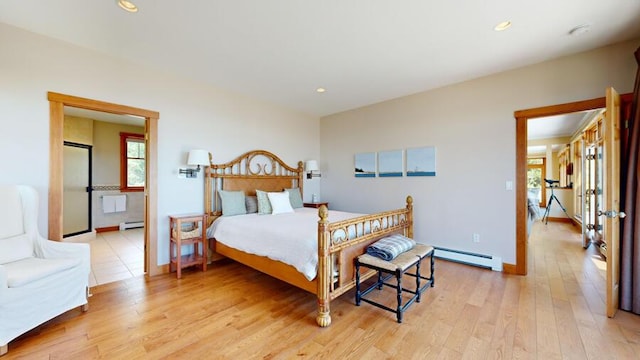 bedroom featuring baseboard heating and light hardwood / wood-style floors