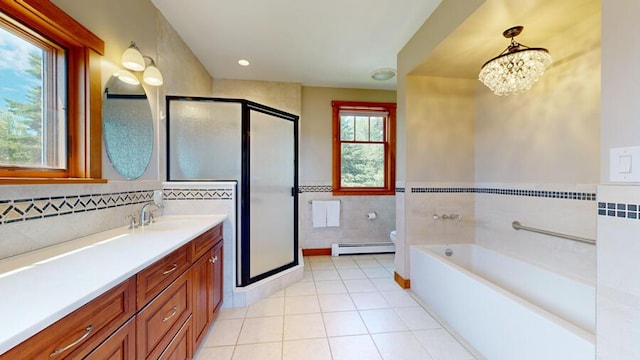 full bathroom with plenty of natural light, toilet, tile walls, and a baseboard heating unit