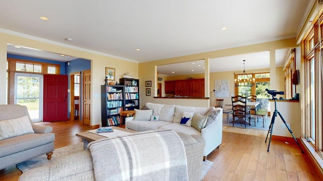 living room with light wood-type flooring, plenty of natural light, and crown molding