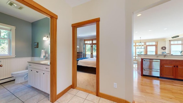 interior space with tile patterned floors, vanity, toilet, and a wealth of natural light