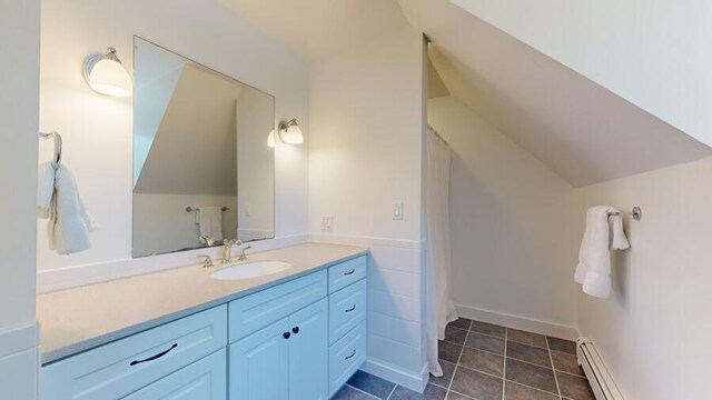 bathroom featuring tile patterned floors, vanity, lofted ceiling, and baseboard heating