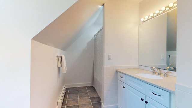 bathroom featuring a shower with shower curtain, tile patterned floors, vanity, a baseboard radiator, and tile walls