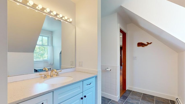 bathroom with baseboard heating, vanity, and vaulted ceiling