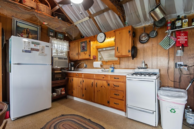 kitchen featuring ceiling fan, sink, white appliances, and wooden walls