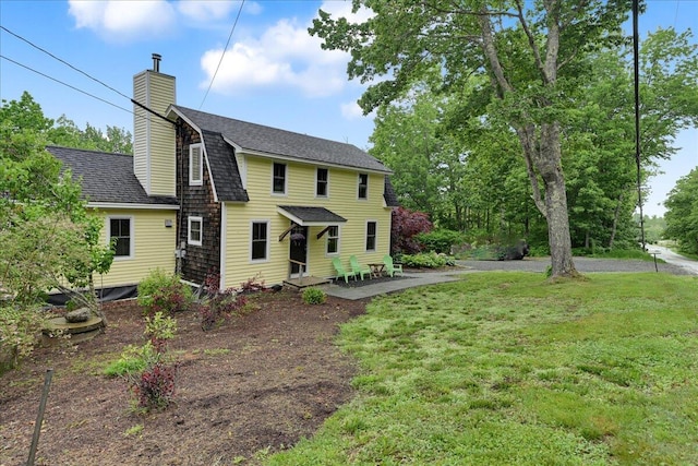 rear view of property with a yard and a patio area