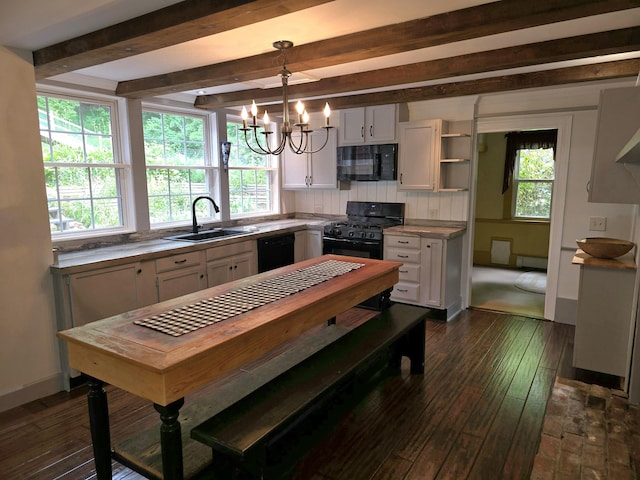 kitchen with pendant lighting, black appliances, plenty of natural light, and sink