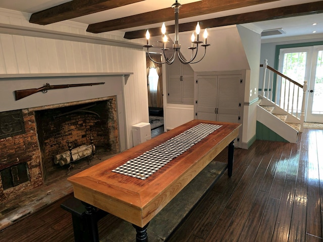 dining space with beam ceiling, wooden walls, dark wood-type flooring, and a notable chandelier