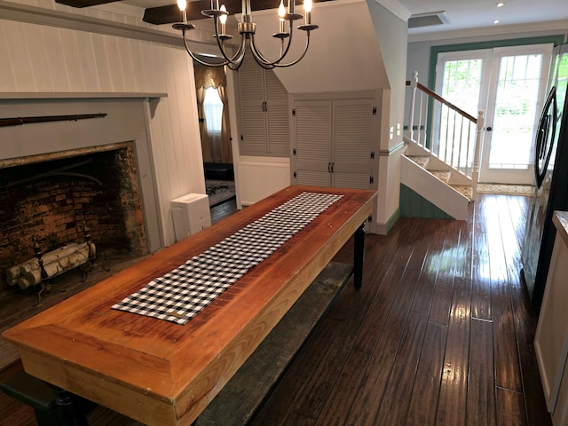 dining area with wood walls, dark hardwood / wood-style flooring, and an inviting chandelier