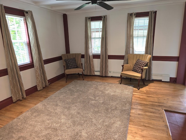 living area featuring beam ceiling, ceiling fan, baseboard heating, hardwood / wood-style flooring, and ornamental molding