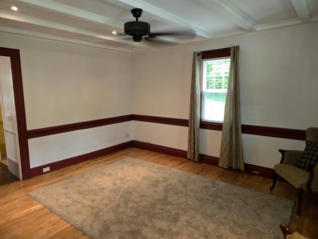 spare room featuring crown molding, beamed ceiling, wood-type flooring, and ceiling fan