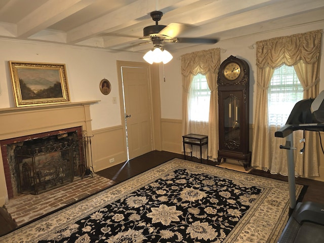 interior space featuring beamed ceiling, ceiling fan, a fireplace, and a wealth of natural light