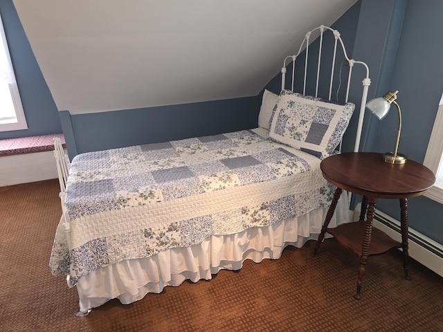 carpeted bedroom with baseboard heating and vaulted ceiling