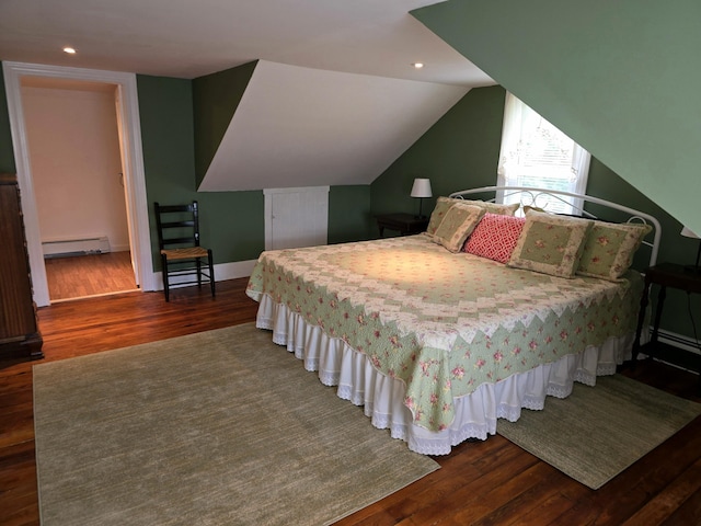 bedroom featuring vaulted ceiling, dark hardwood / wood-style flooring, and a baseboard heating unit