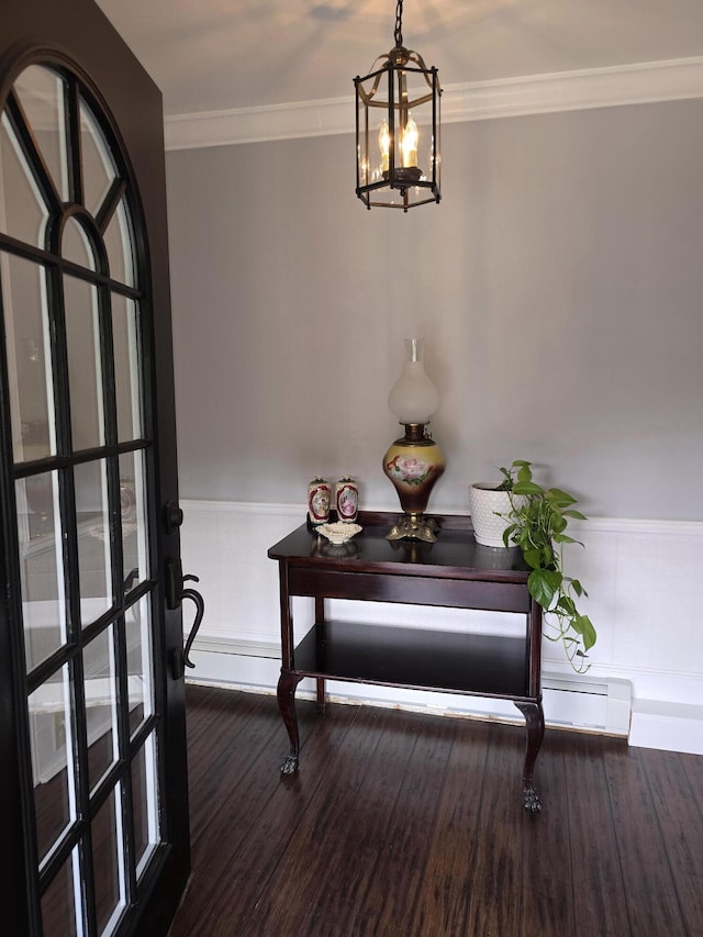 entryway featuring ornamental molding, an inviting chandelier, and dark wood-type flooring