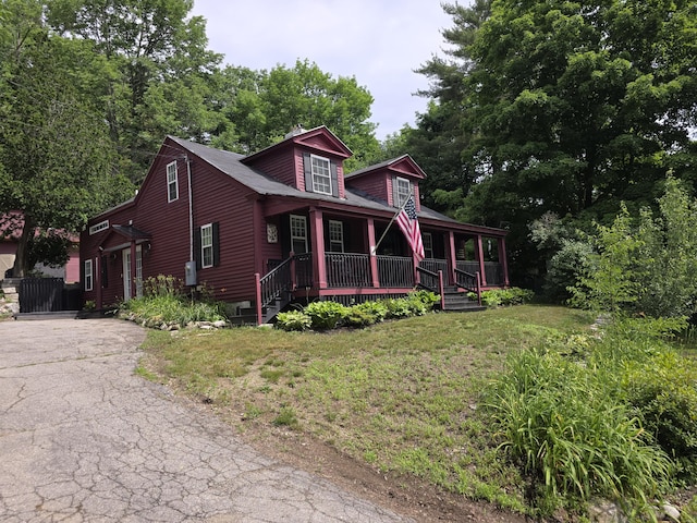 view of front of property featuring covered porch and a front yard