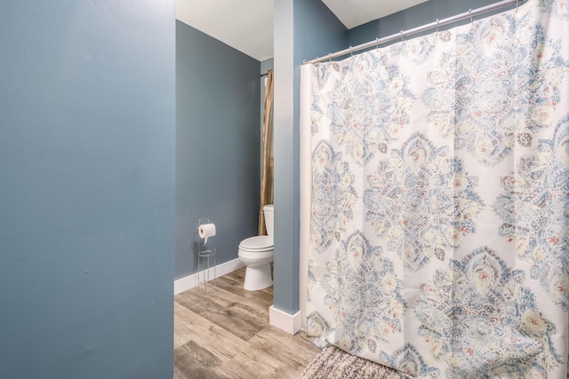 full bathroom featuring baseboards, toilet, curtained shower, and wood finished floors