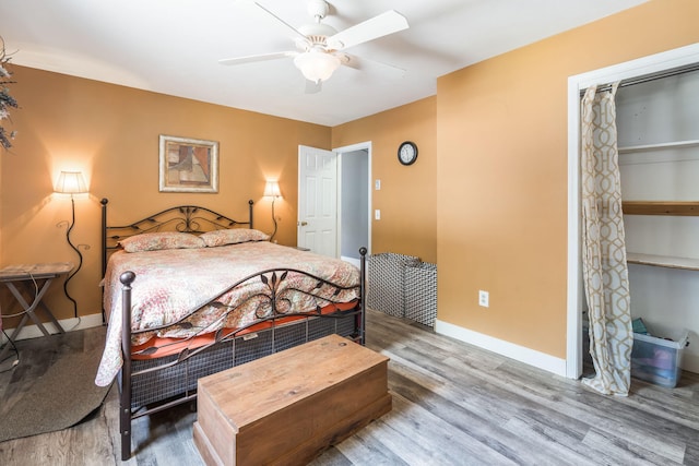 bedroom featuring a ceiling fan, baseboards, and wood finished floors