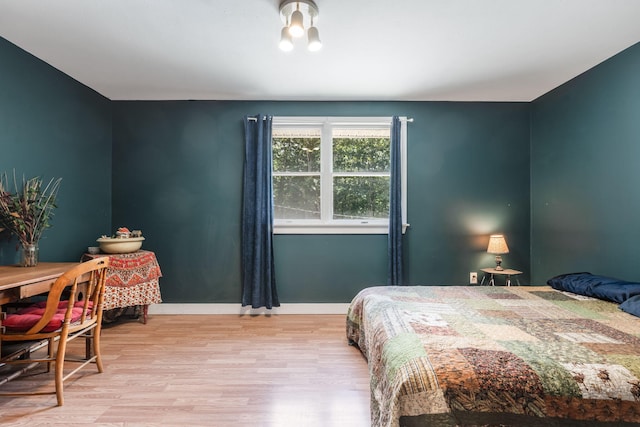 bedroom featuring baseboards and wood finished floors