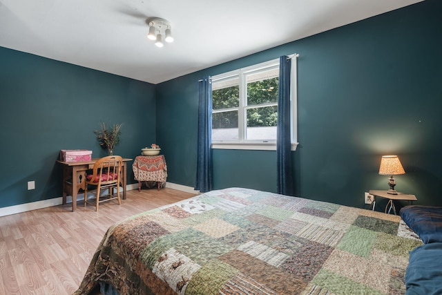bedroom with baseboards and wood finished floors