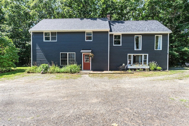 view of front of house with a chimney and a shingled roof