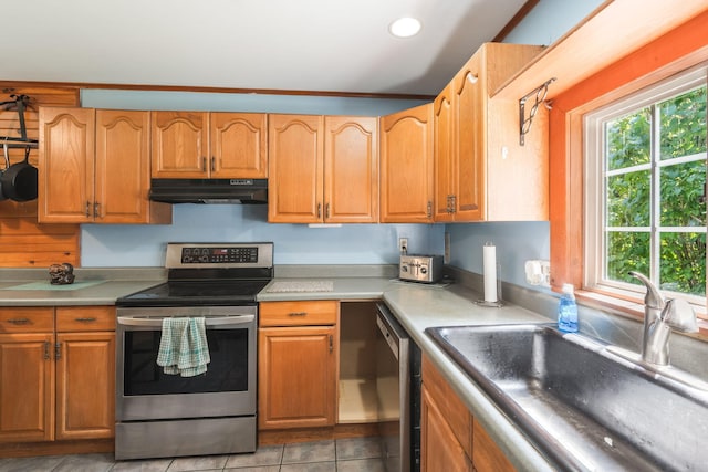 kitchen with light tile patterned flooring, light countertops, appliances with stainless steel finishes, under cabinet range hood, and a sink