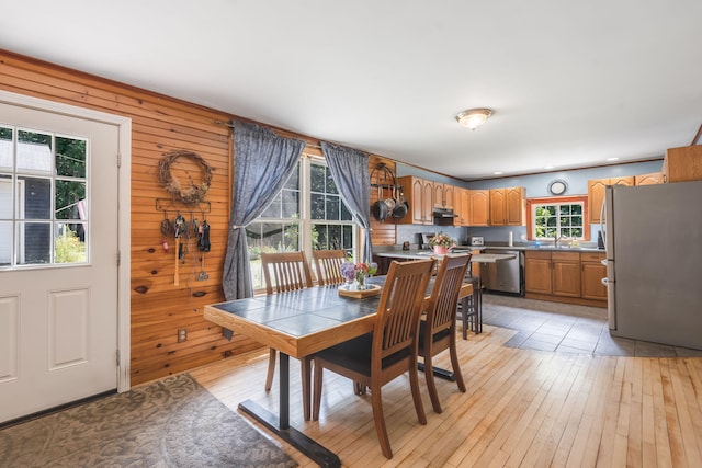 dining area featuring wooden walls and light wood-type flooring