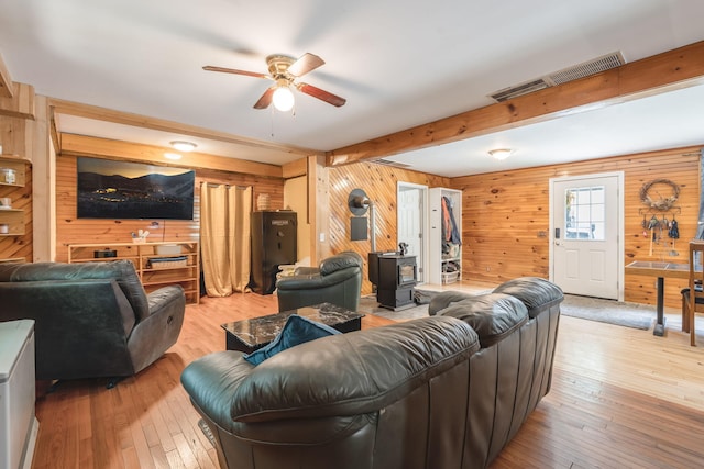 living room with beamed ceiling, visible vents, hardwood / wood-style flooring, and a ceiling fan