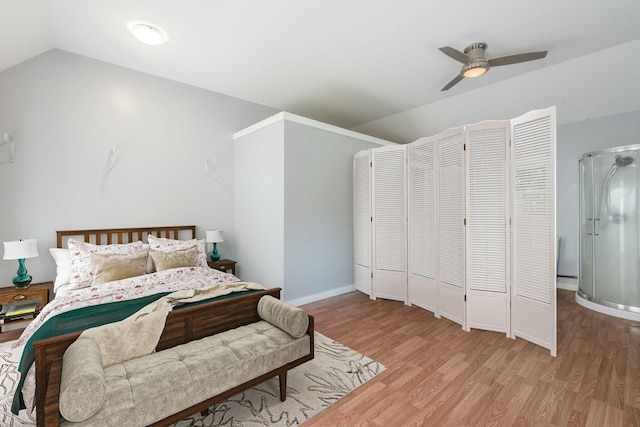 bedroom featuring a ceiling fan, baseboards, vaulted ceiling, and light wood-type flooring