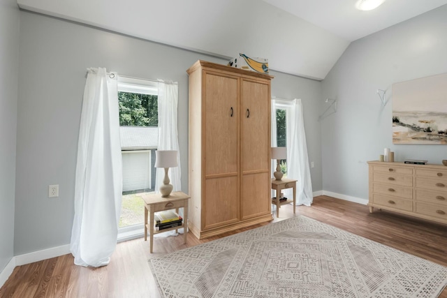 unfurnished room with baseboards, lofted ceiling, and wood finished floors