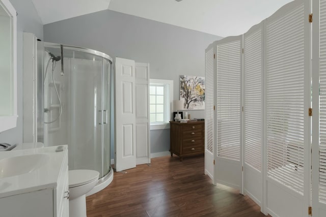 full bathroom featuring vanity, a shower stall, vaulted ceiling, and wood finished floors