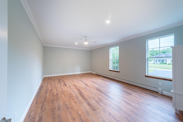 spare room featuring ornamental molding, light wood-type flooring, ceiling fan, and a baseboard heating unit