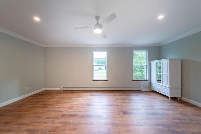 spare room with ceiling fan, crown molding, baseboard heating, and dark wood-type flooring