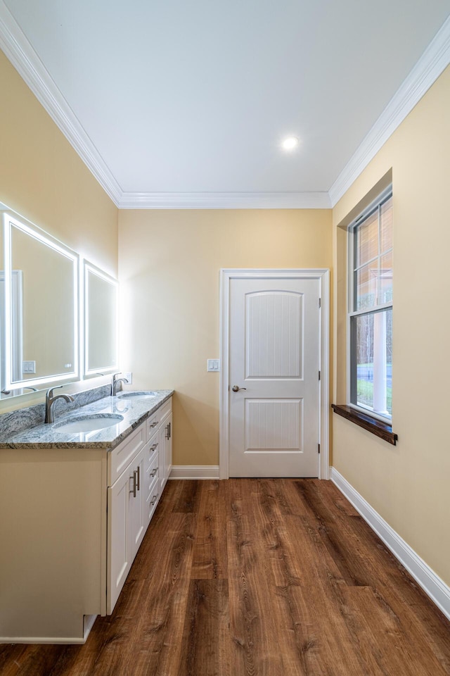 bathroom with hardwood / wood-style floors, vanity, and ornamental molding