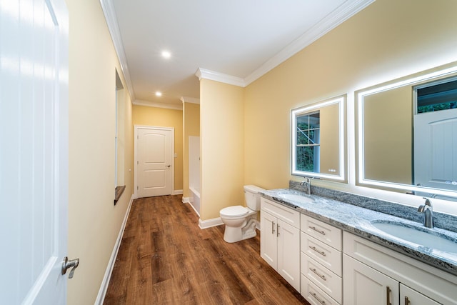 bathroom featuring vanity, toilet, wood-type flooring, and ornamental molding