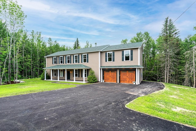 view of front facade featuring a porch, a garage, and a front lawn