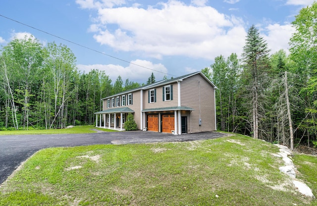 view of front of home with a porch, a garage, and a front lawn