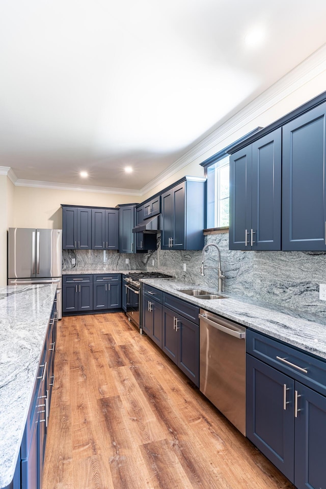 kitchen with blue cabinets, sink, decorative backsplash, appliances with stainless steel finishes, and light stone counters