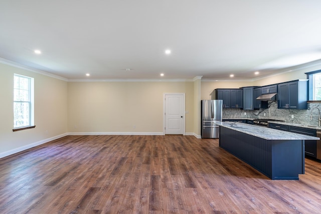 kitchen featuring stainless steel fridge, tasteful backsplash, dark wood-type flooring, crown molding, and a kitchen island