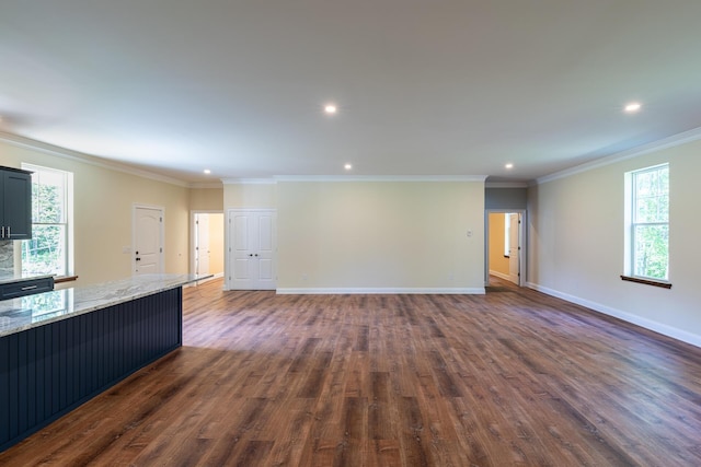 unfurnished living room with crown molding, plenty of natural light, and dark hardwood / wood-style floors