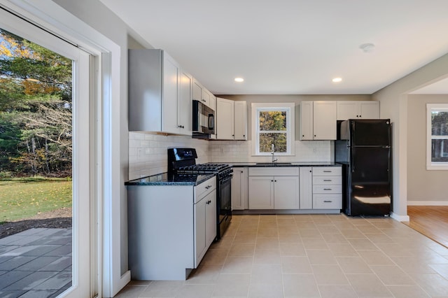 kitchen featuring white cabinetry, sink, and black appliances