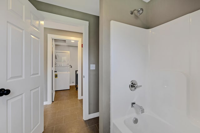 bathroom featuring stacked washer and dryer, shower / washtub combination, and tile patterned floors