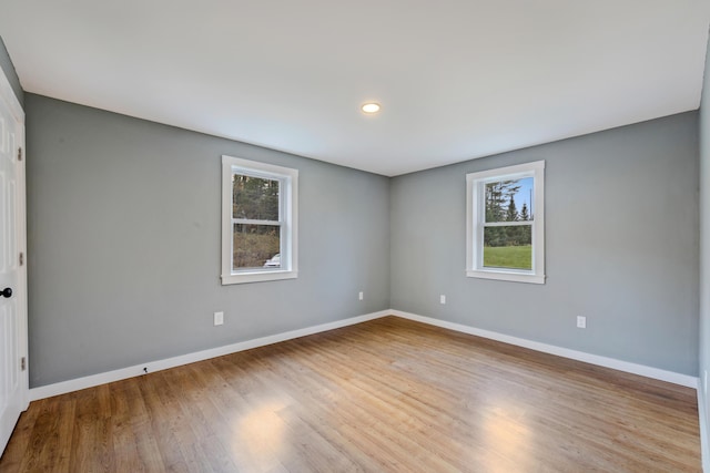 unfurnished room with a healthy amount of sunlight and light hardwood / wood-style floors