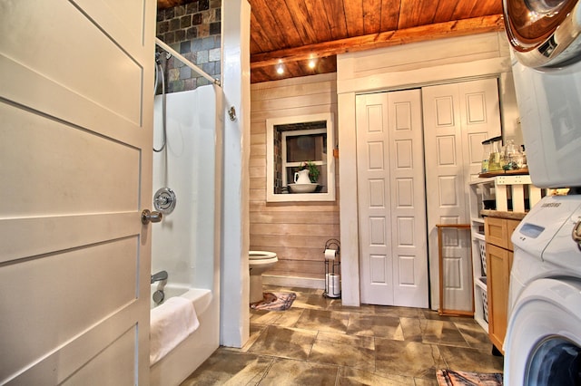 laundry area featuring wooden ceiling, stacked washer and clothes dryer, and wooden walls