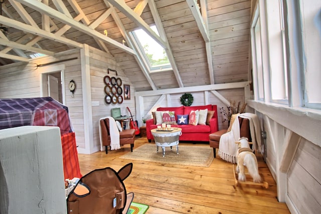 interior space featuring wood-type flooring, lofted ceiling with skylight, wood walls, and wood ceiling